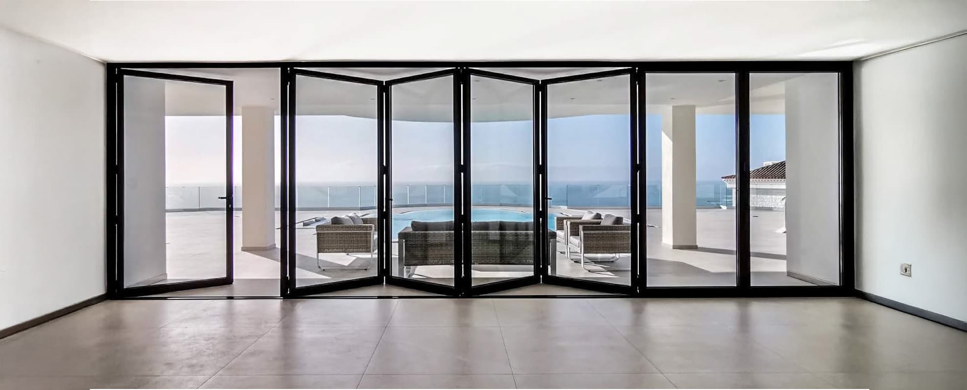 Slim aluminium bi-fold doors opening onto a rooftop terrace
