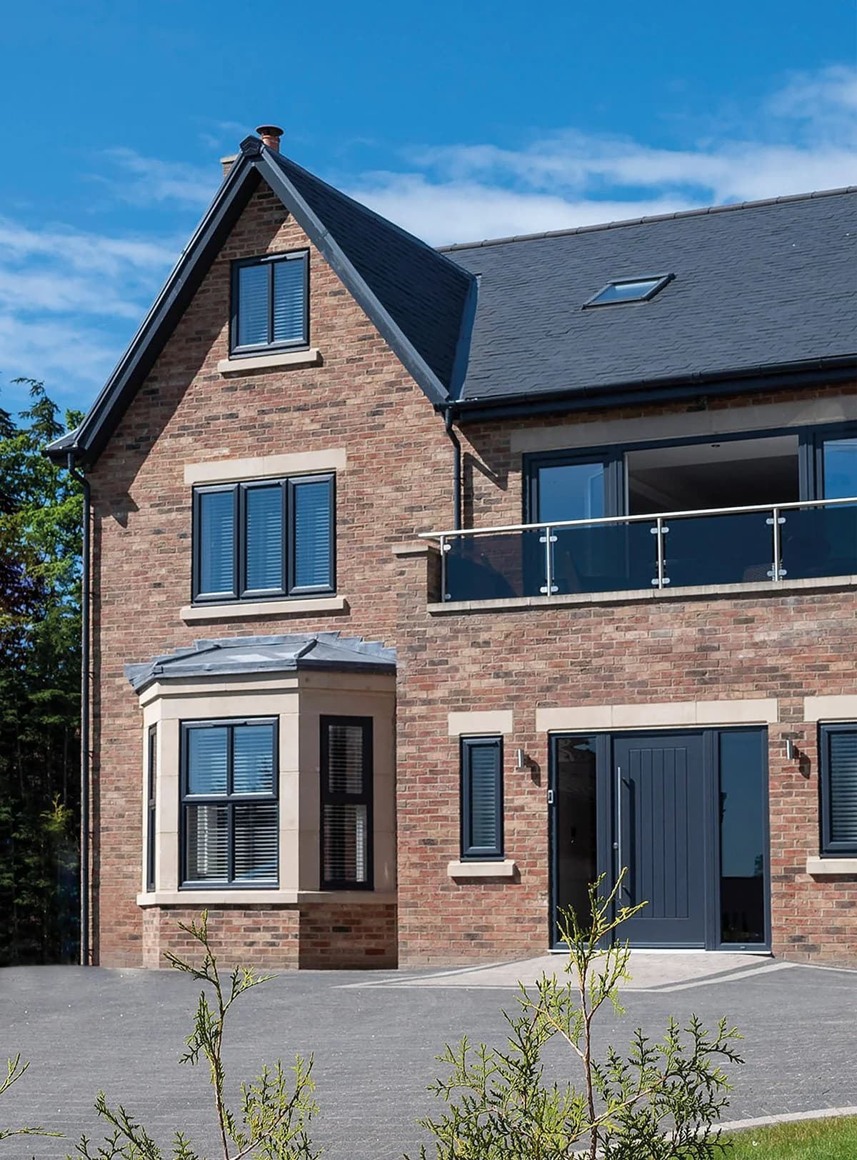 A detached house with a pitched tiled roof and white casement windows
