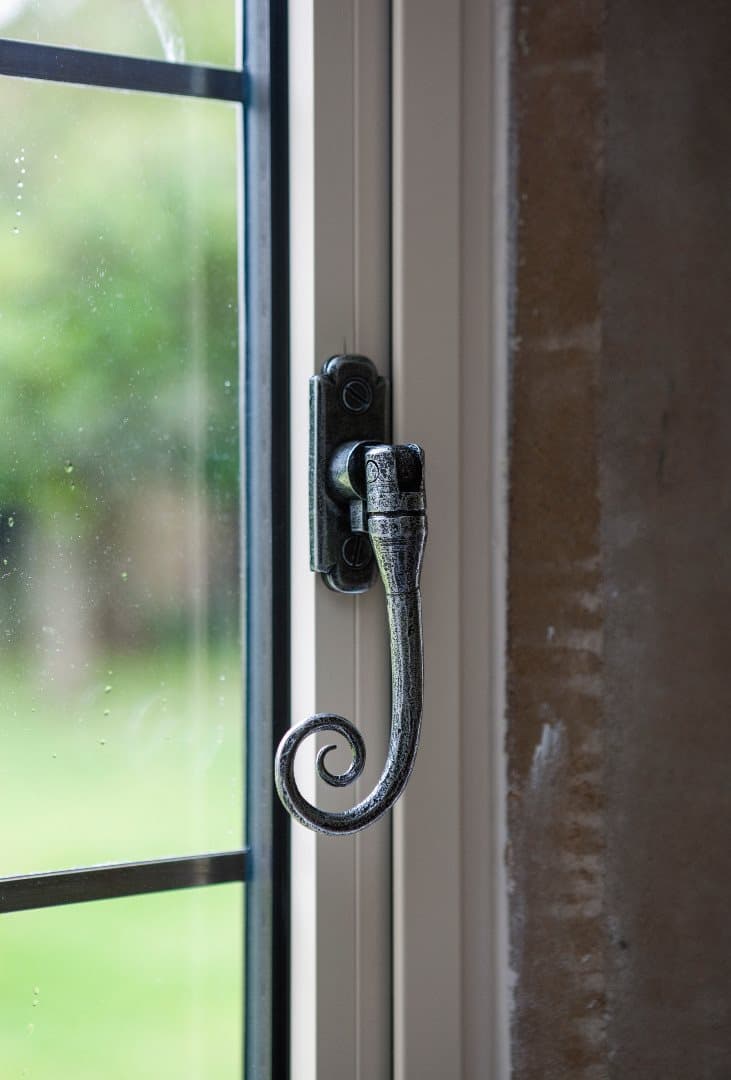 A Monkey Tail casement handle in a black Heritage finish