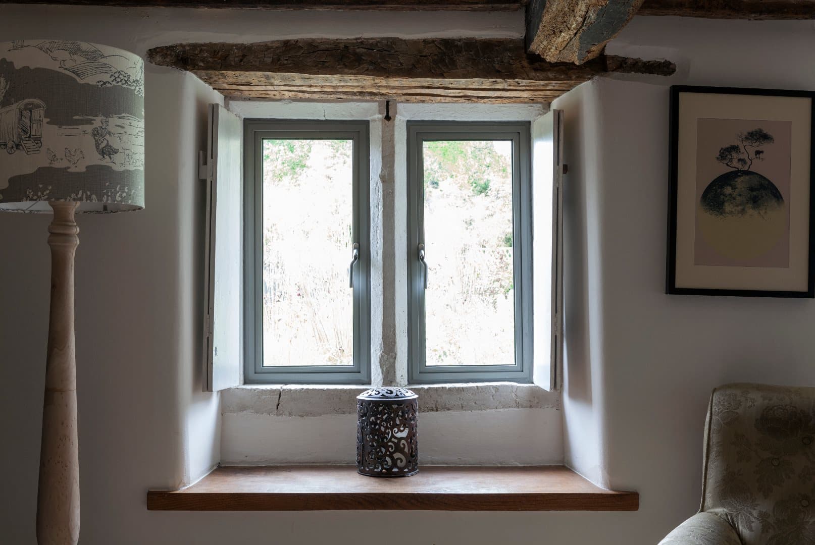 A slim anthracite Alitherm Heritage aluminium window above a cottage window seat