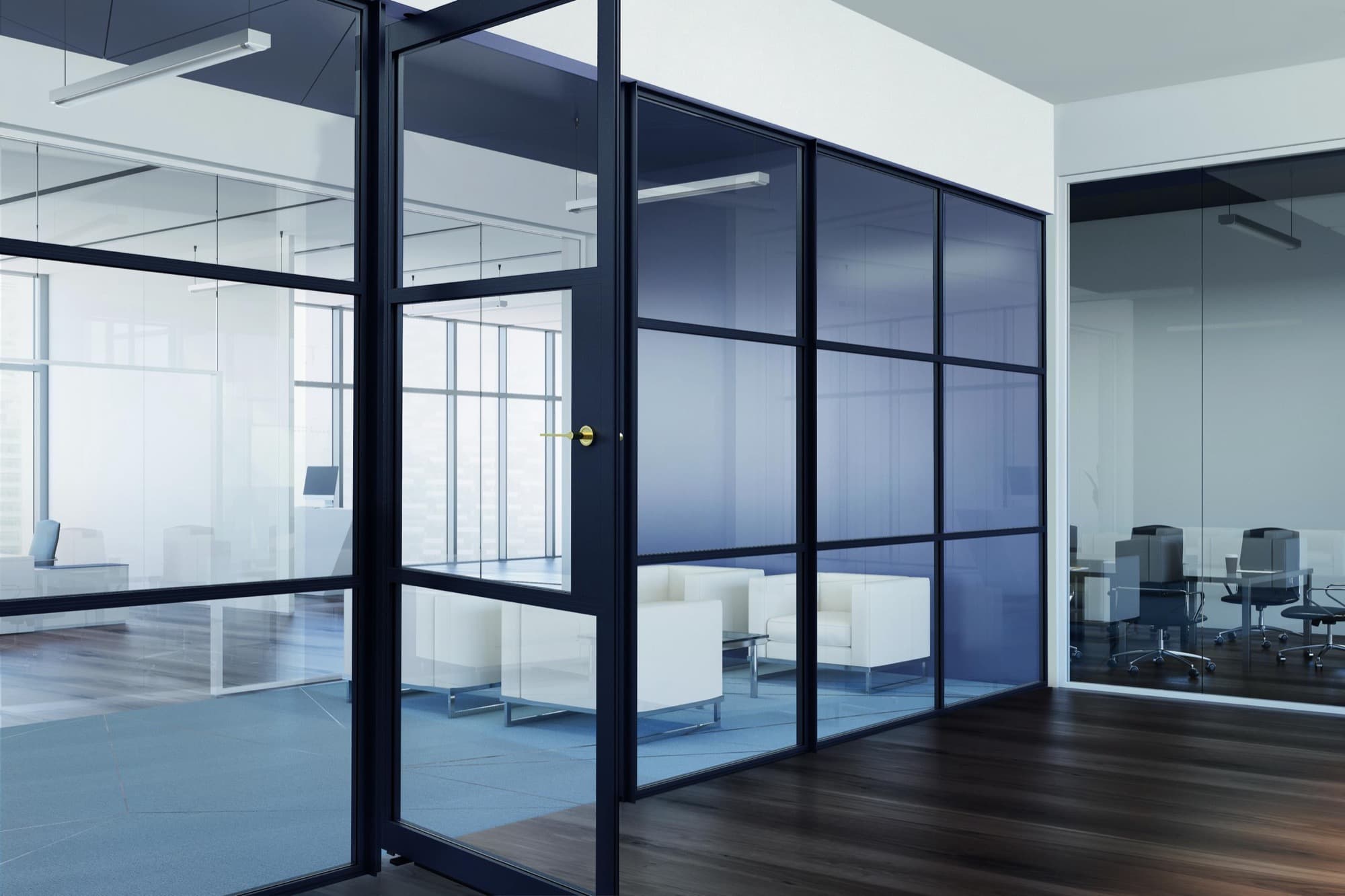 A full-height black-framed AluSpace glazed wall dividing an open-plan space