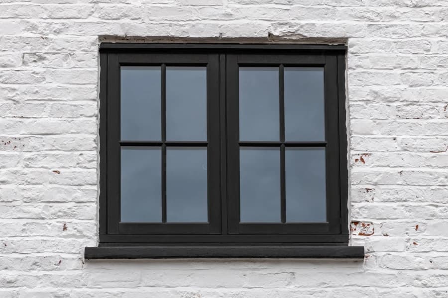 Black woodgrain flush casement windows in a rendered elevation