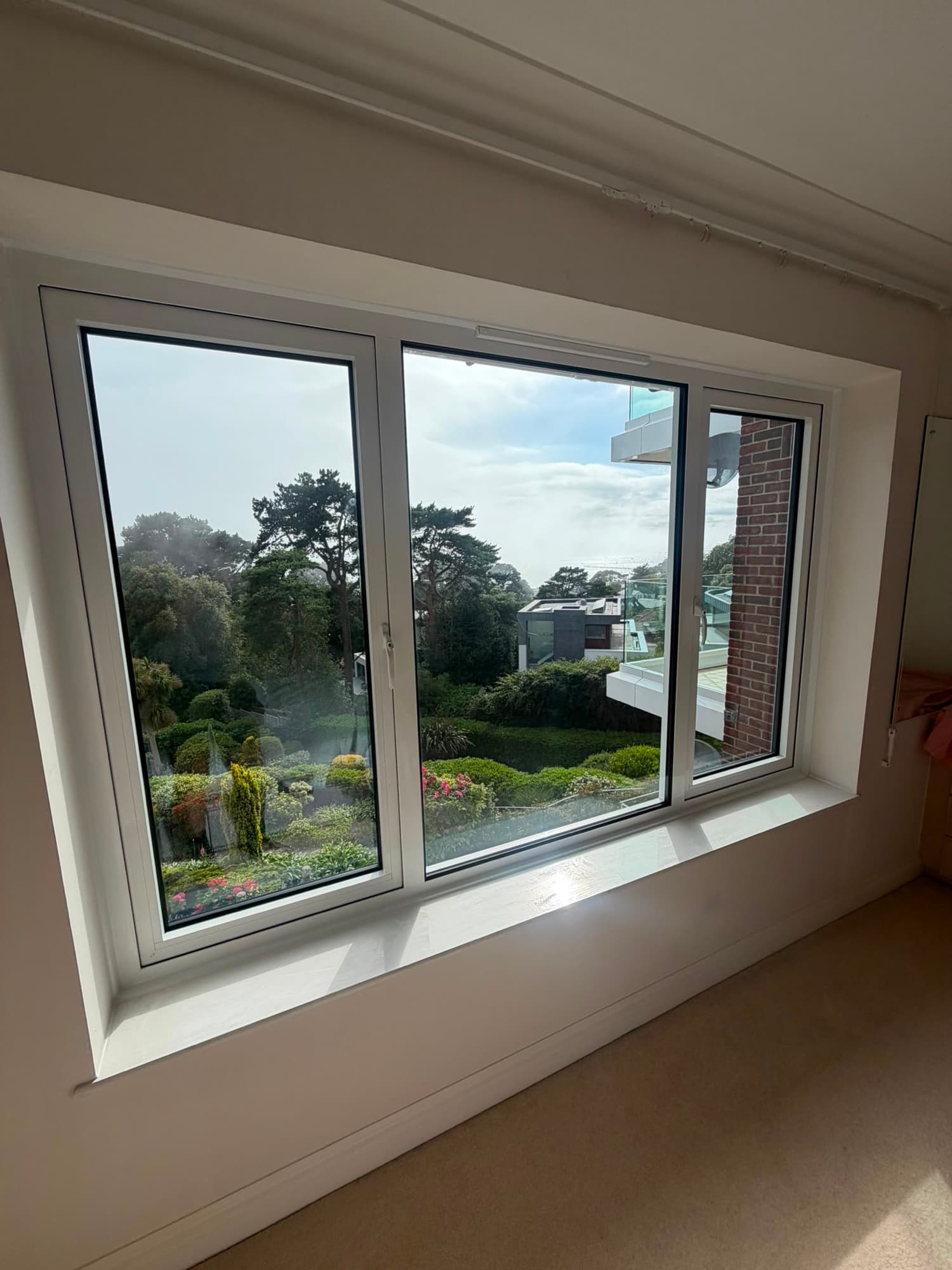 A white aluminium casement window seen from inside, one of our own installations