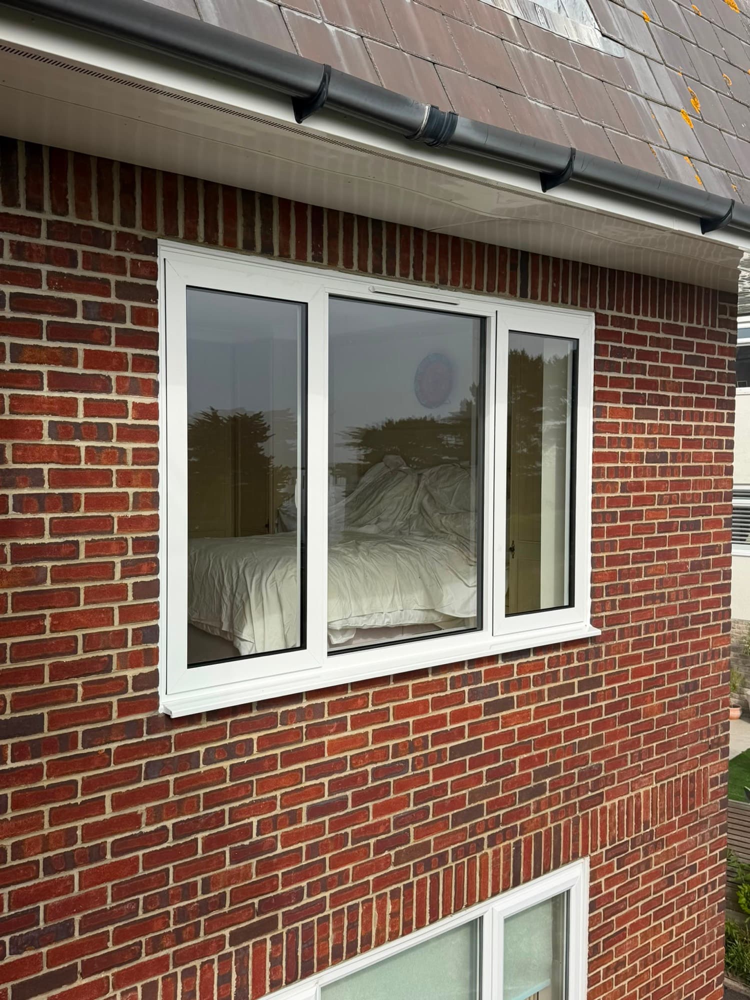 A white aluminium casement window fitted in a brick elevation by Wilshaw Glazing