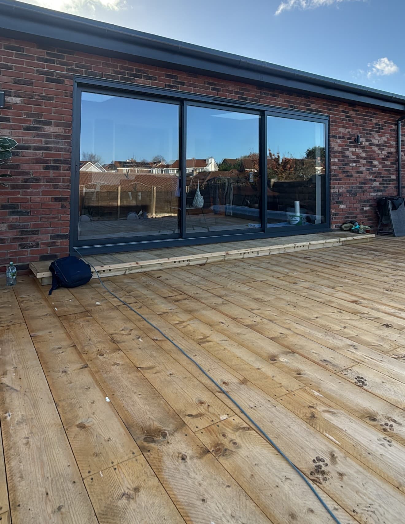 An anthracite aluminium sliding patio door onto decking, one of our own installations