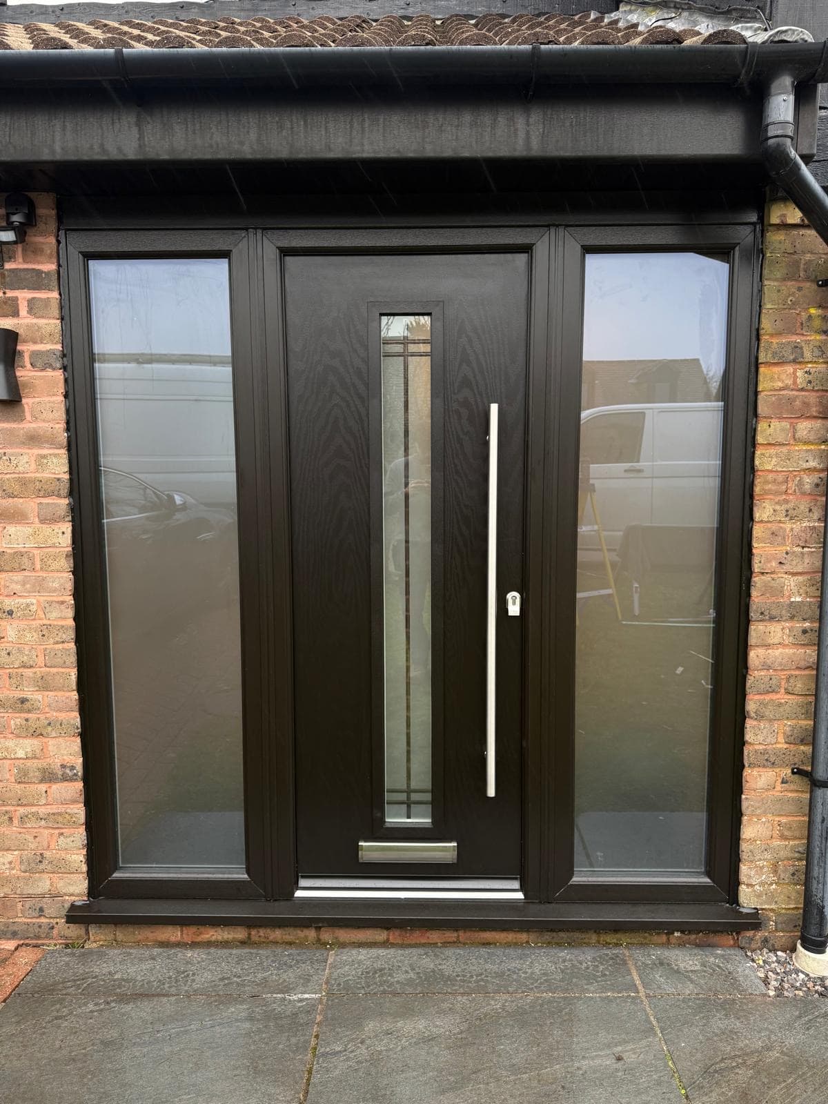 A dark composite front door with a narrow leaded-glass panel, fitted with full-height sidelights, a real Wilshaw installation