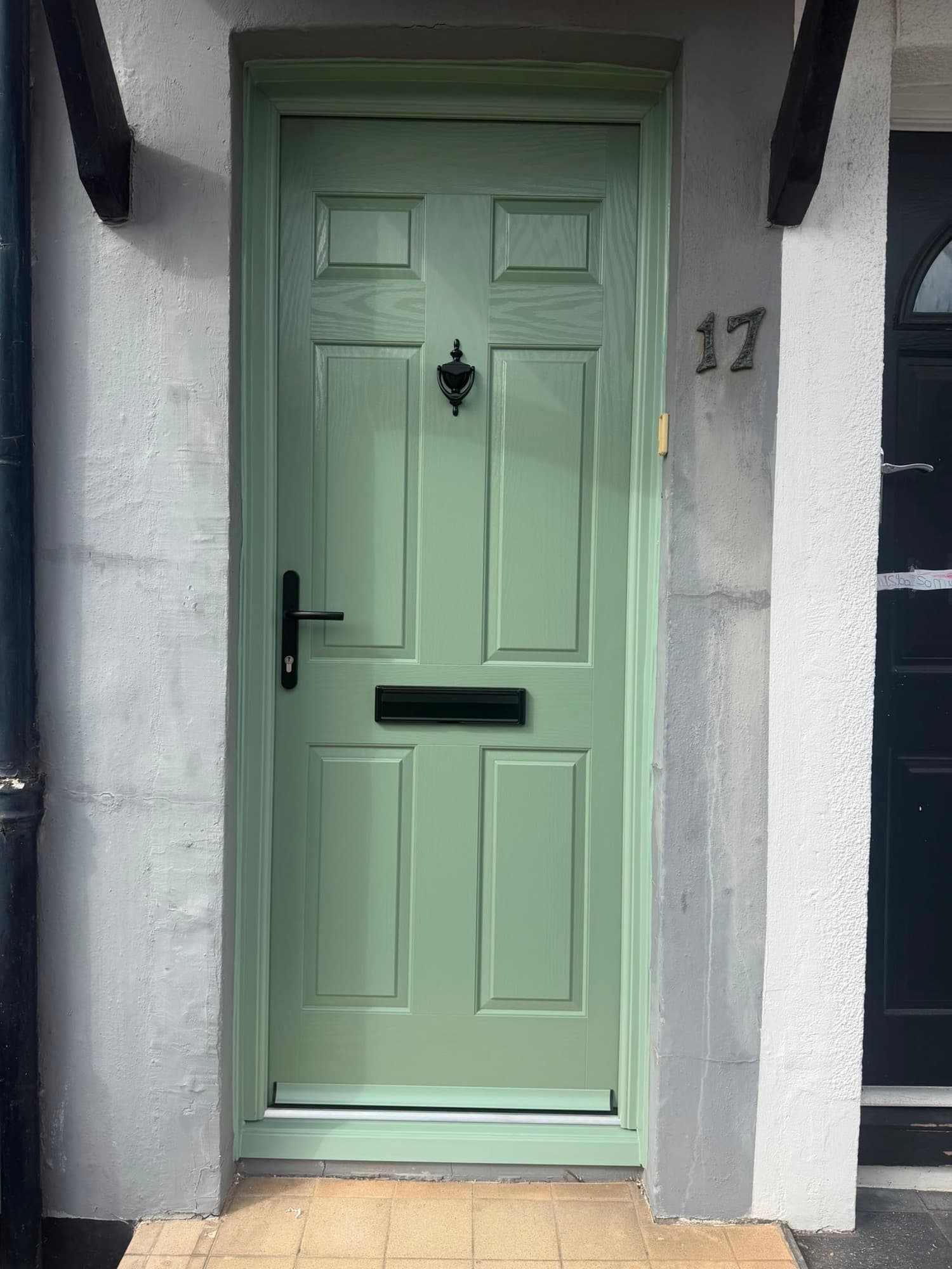 A sage-green six-panel composite front door, a real Wilshaw installation
