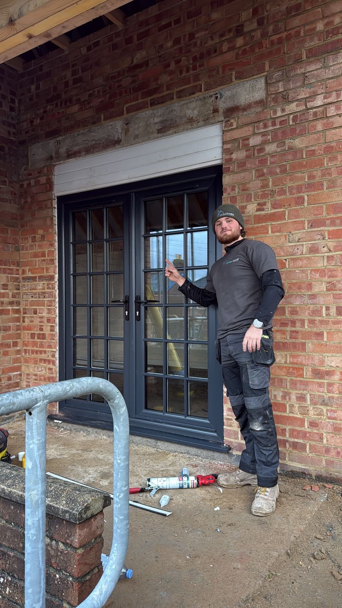 Josh checking the hardware on a set of anthracite aluminium French doors he has just fitted