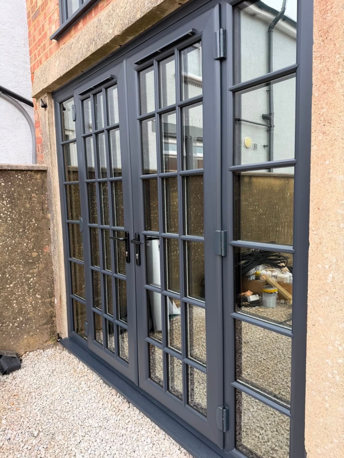 Josh fitting anthracite aluminium French doors on a Wilshaw installation