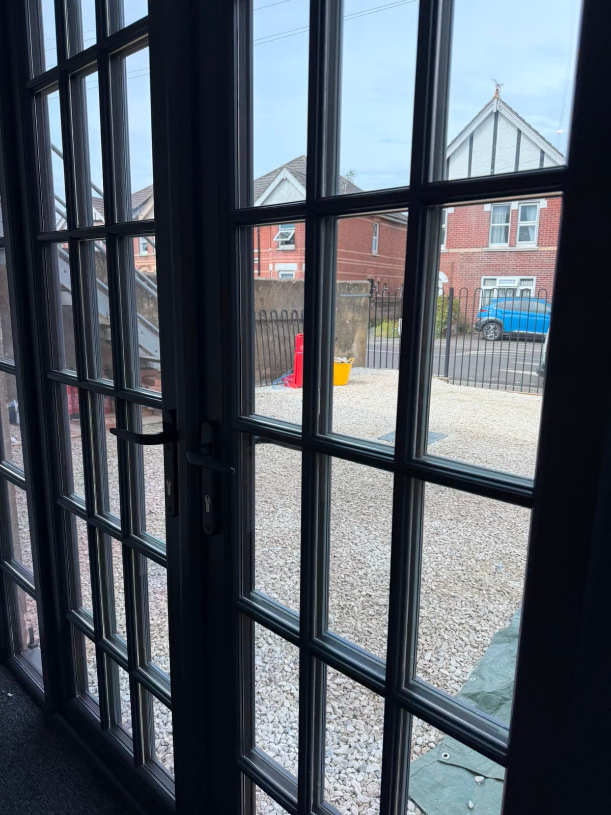 Slim anthracite aluminium French doors seen from inside a bright room, fitted by Wilshaw Glazing