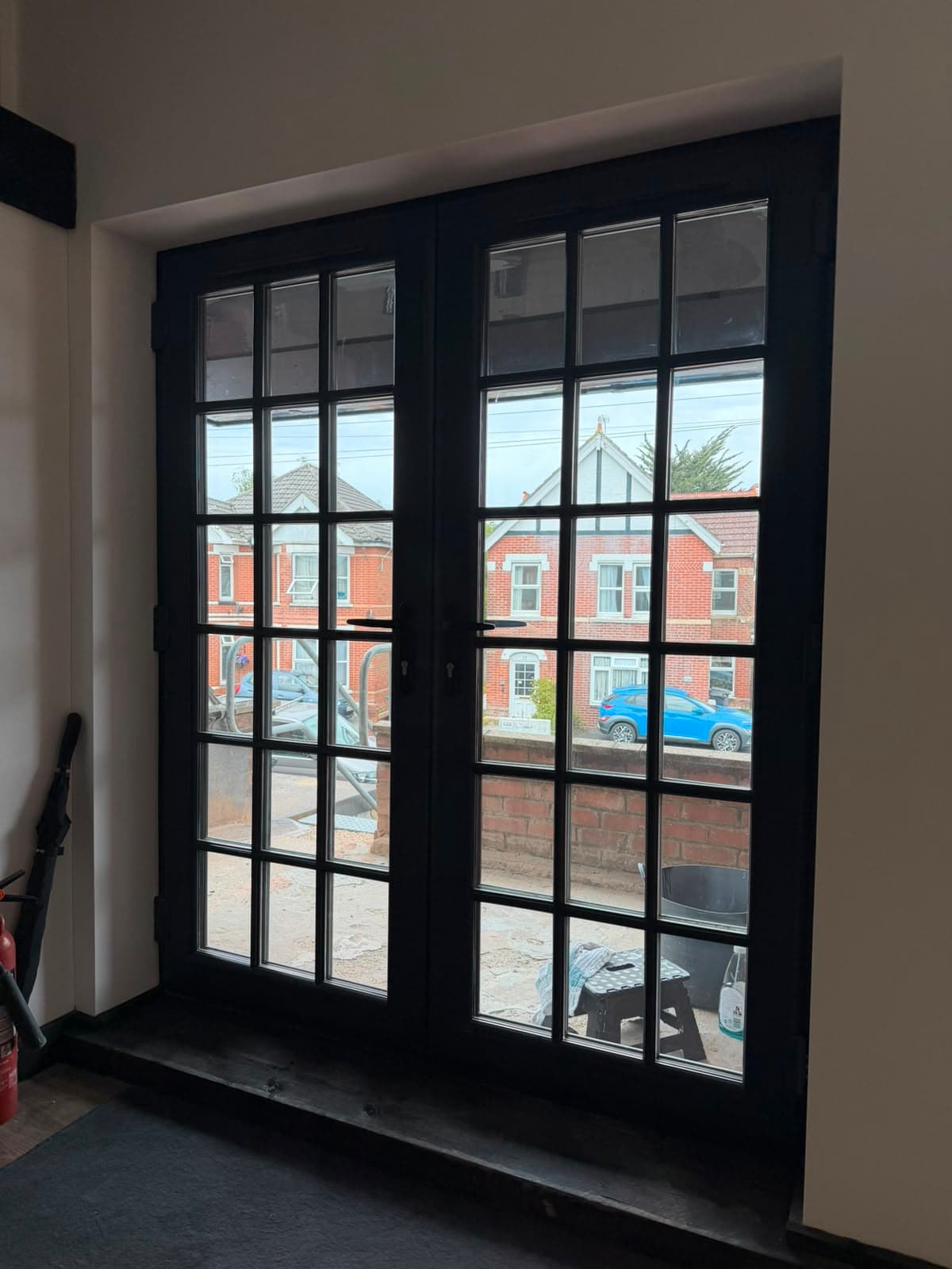 Slim anthracite aluminium doors seen from inside a bright room, fitted by Wilshaw Glazing