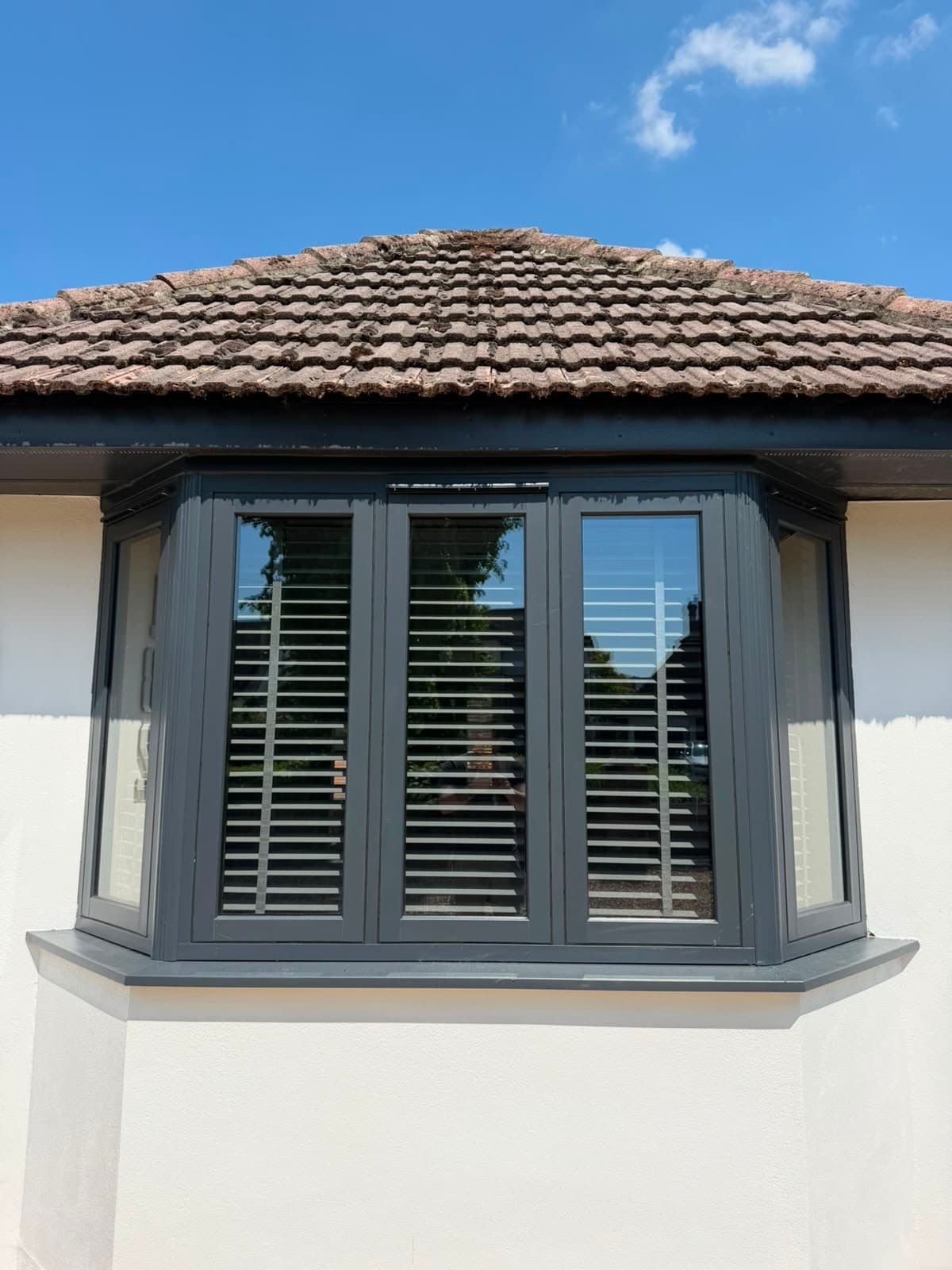 Anthracite timber-look flush casement windows in a bay, fitted by Wilshaw Glazing