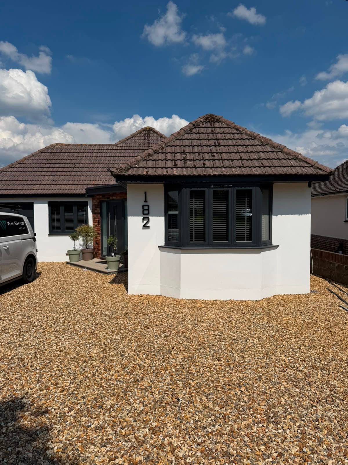 A home elevation fitted with anthracite timber-look flush casement windows, a real Wilshaw installation