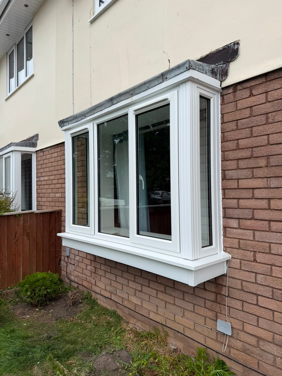 A white uPVC bay window in a Tudor-timbered period frontage, fitted by Wilshaw Glazing